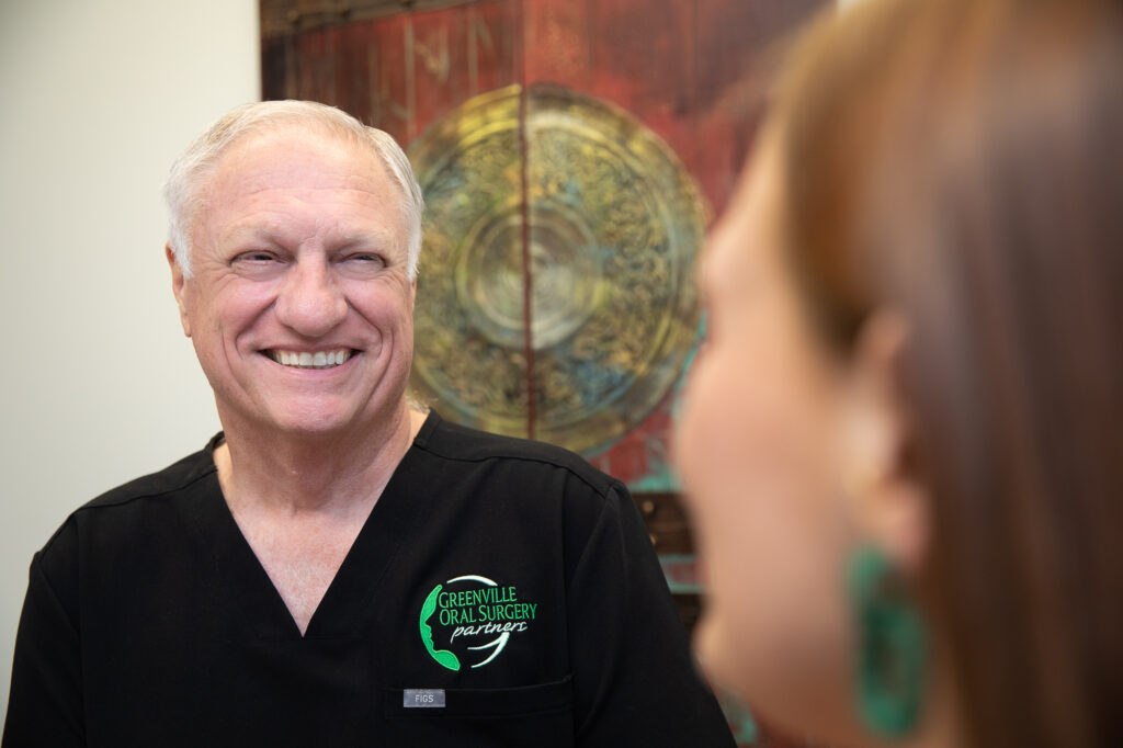 Dr. Larry Cobb helping an oral surgery patient at Greenville Oral Surgery